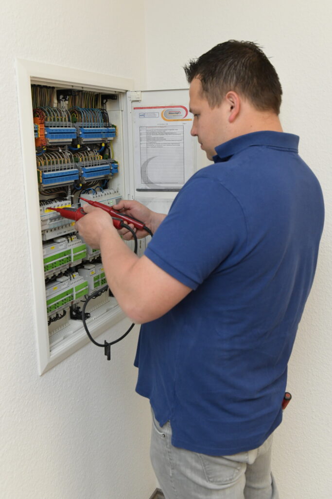 Elektroniker Jobs Troisdorf – Monteur arbeitet am Sicherungskasten (Elektro Schwarzkopf)